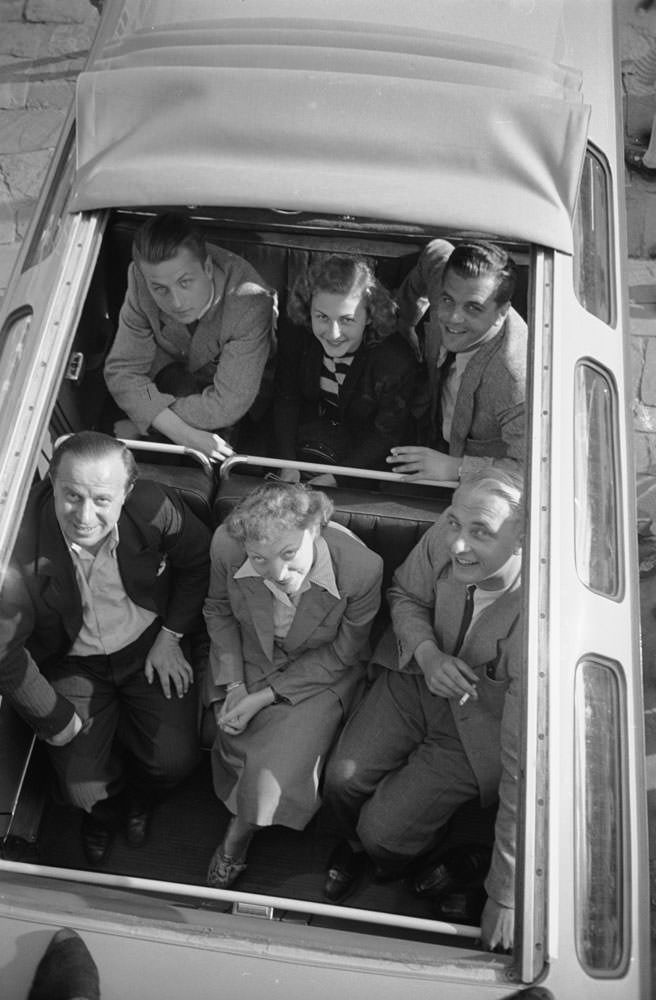 People gaze at photographer Walter Sanders through the open roll-top of a VW bus, 1951.