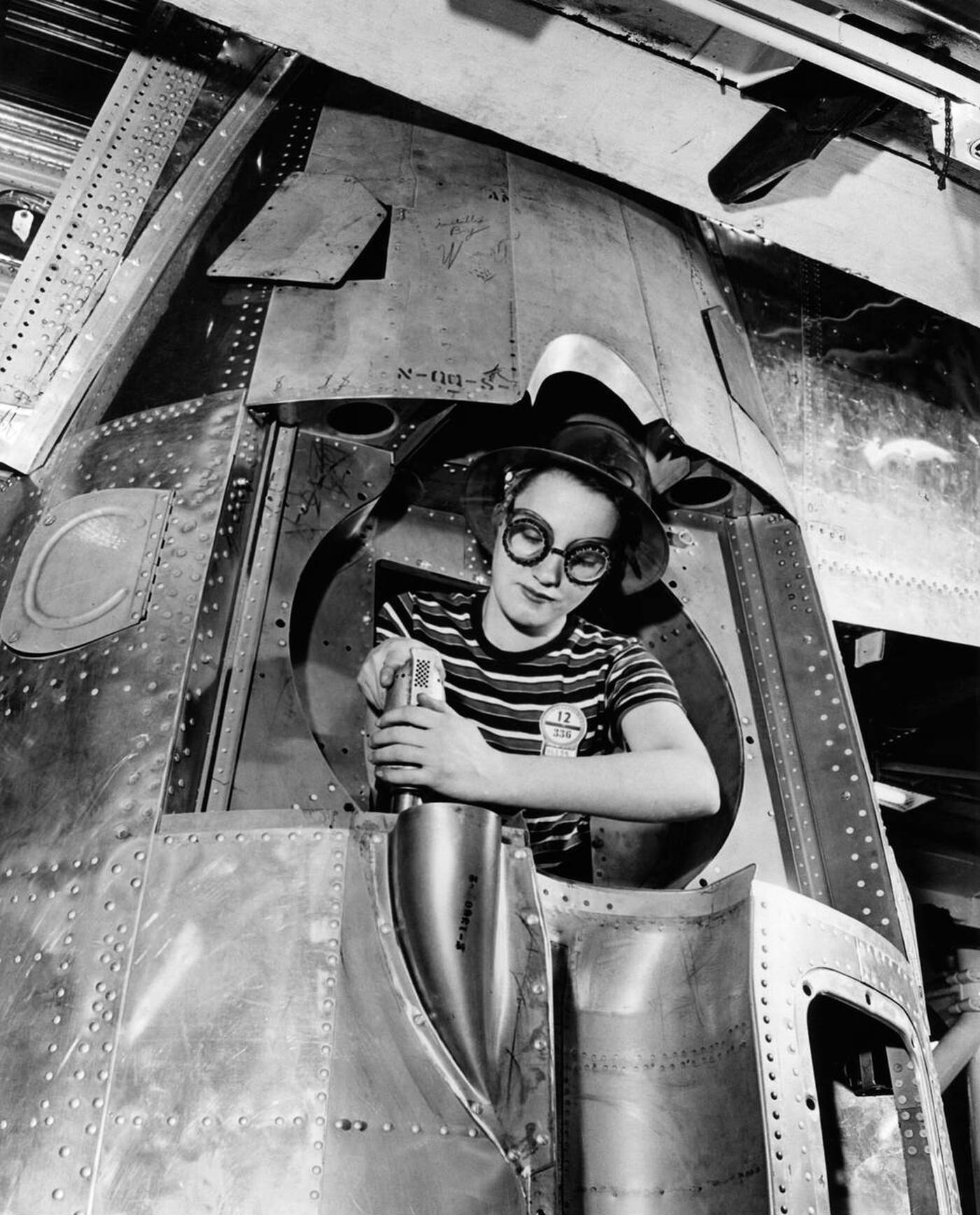 A woman riveter drilling a hole, 1940s