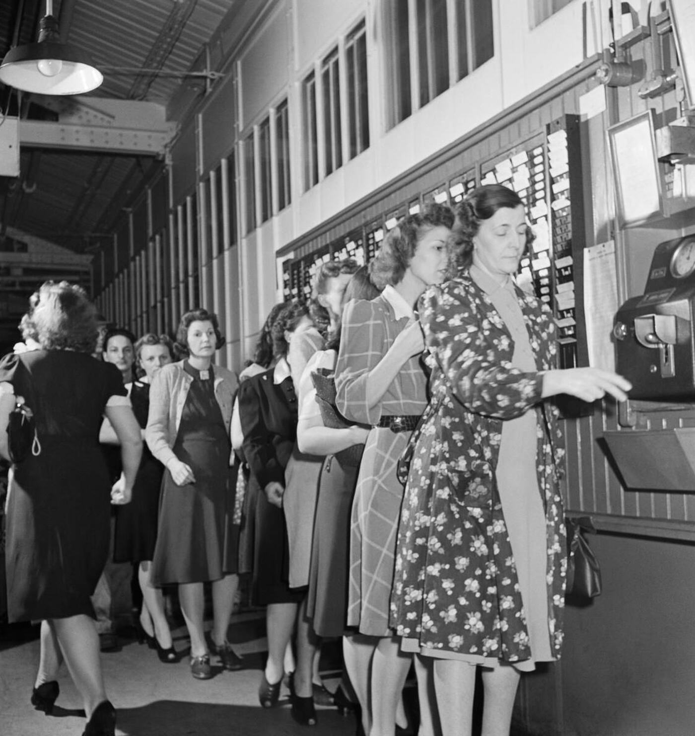 Workers punching time cards, World War II