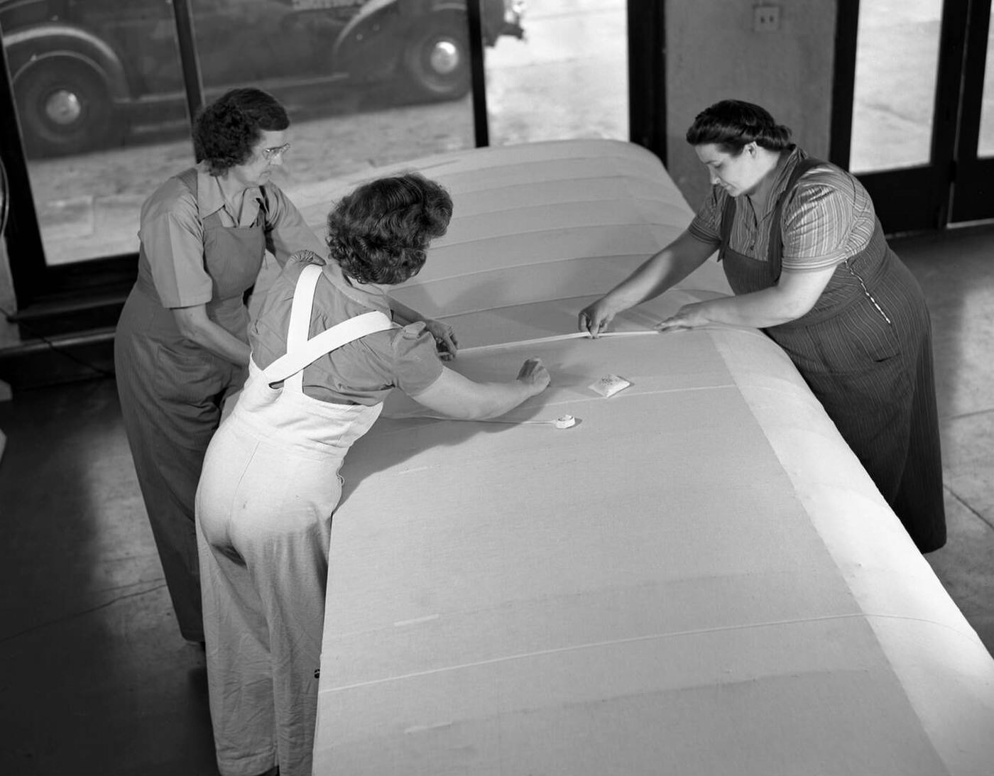 Women sewing on an airplane wing, 1942
