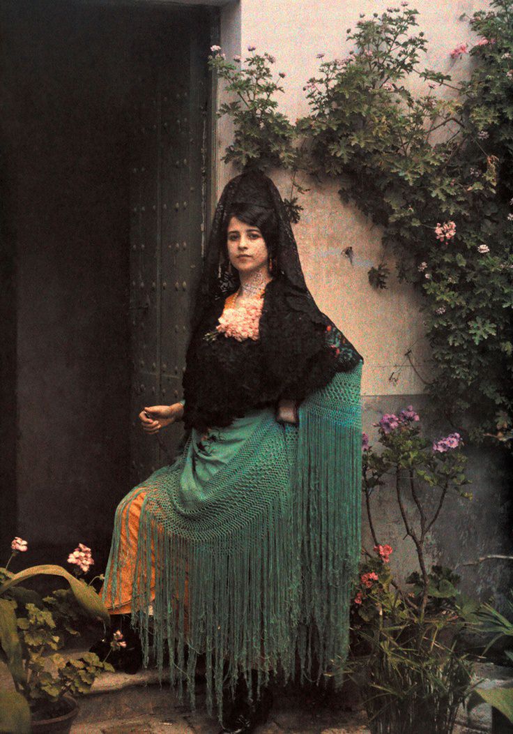 A woman dressed for a bullfight stands in a doorway, August 1924.