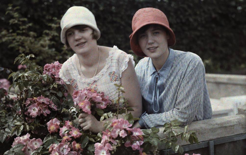 Two young women pose together in a rose garden in Cologne, 1929.