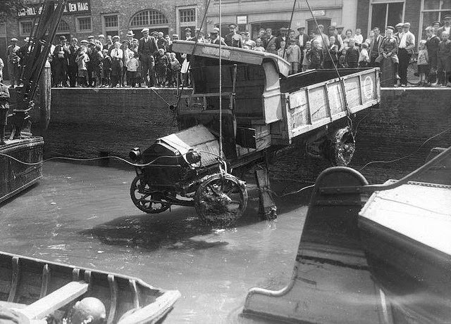 A hoisted truck attracts public interest in Port Kuipers Dordrecht, Netherlands, 1922.