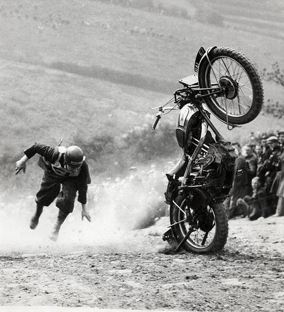 Motorcycle racing accident in England; the bike is upright in the sand, rider still airborne, 1935.