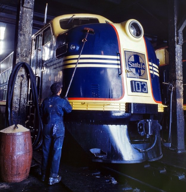 March 1943. Washing one of the Santa Fe R.R. 5,400-horsepower diesel freight locomotives in the roundhouse at Argentine, Kansas. 4×5 Kodachrome transparency by Jack Delano.
