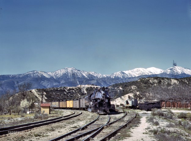 March 1943. “An eastbound Union Pacific freight waiting in a siding at Alray, California. Coming up through Cajon Pass. The Santa Fe tracks are used by the Union Pacific as far east as Daggett, Calif.” One of many images taken by Jack Delano documenting a Santa Fe freight train’s journey from Chicago to California. 4×5 Kodachrome transparency. Office of War Information.