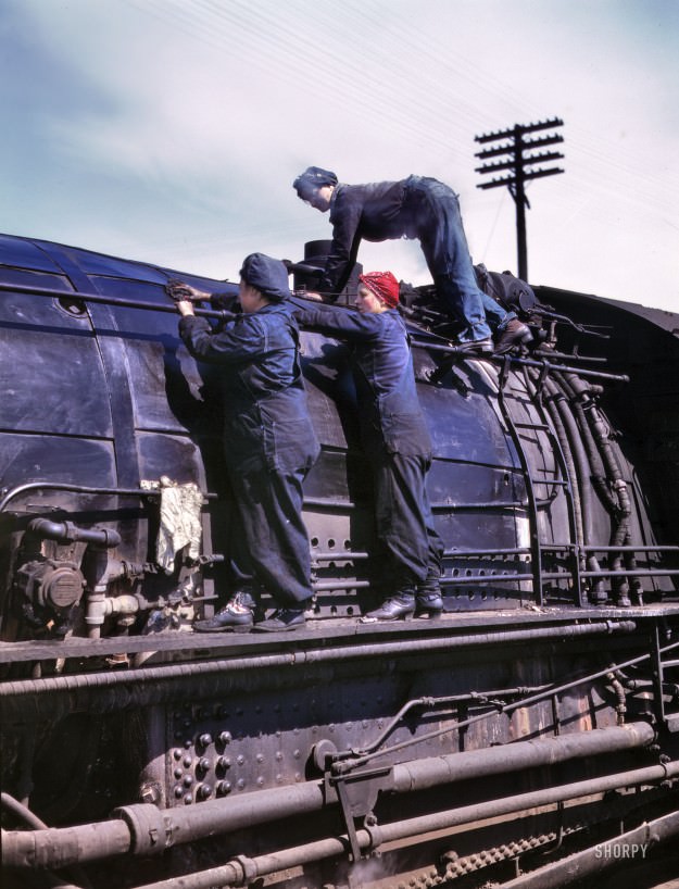 Clinton, Iowa. April 1943. “Chicago & North Western Railroad. Women wipers at the roundhouse cleaning one of the giant H-class locomotives.” In the red bandanna: Marcella Hart, seen here in a few other posts. 4×5 Kodachrome transparency by Jack Delano for the Office of War Information.
