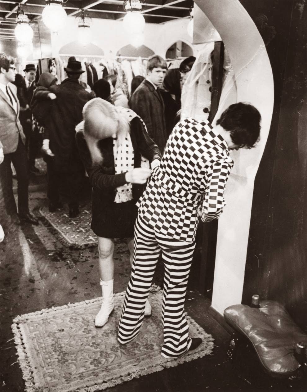 December 1966: A shop assistant helps a customer in a fashion boutique.