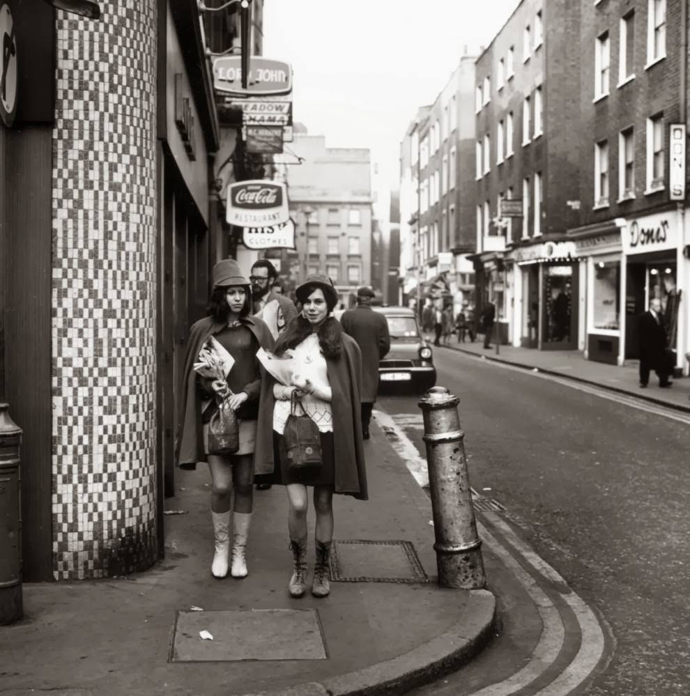 circa 1967: Two young women walk down the street.