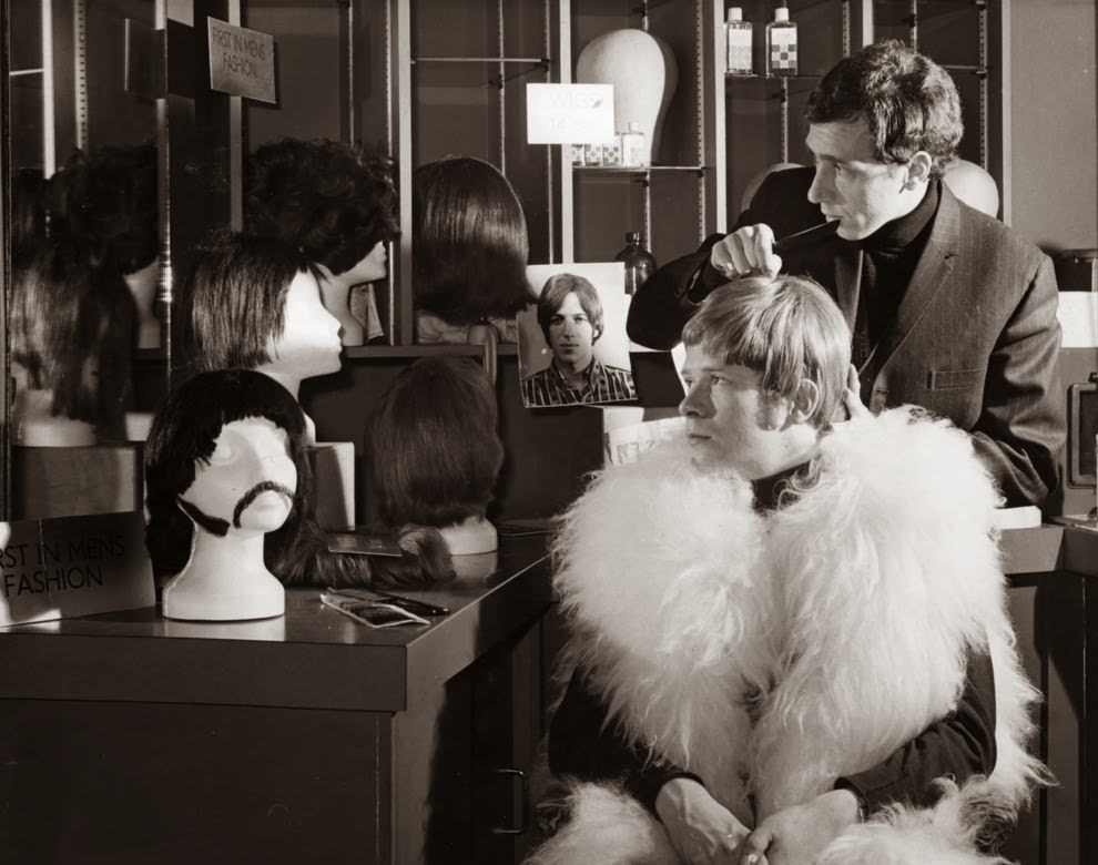 circa 1968: Pop singer Long John Baldry being fitted with a wig at the John Stephen wig centre.
