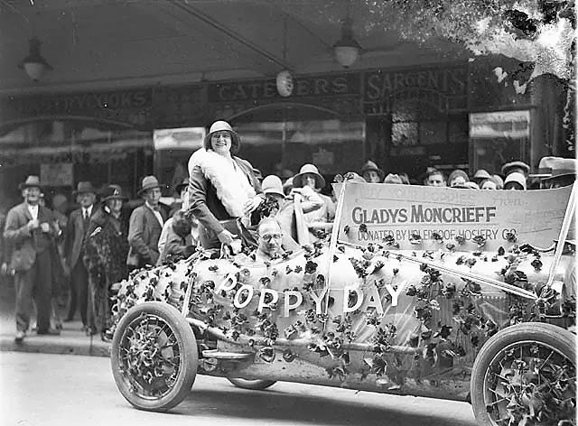 Gladys Moncrieff rides a poppy-laden float, donated by Holeproof Hosiery Company, 1920s.