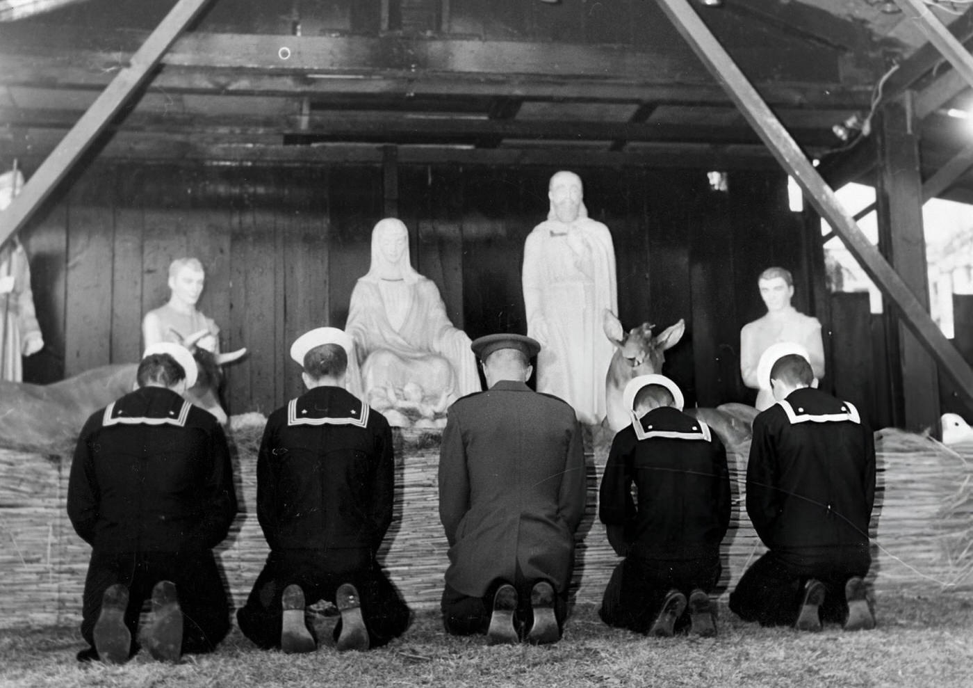 Four sailors and a soldier stop to pray in front of the Christmas decorations on Boston Common, 1965.