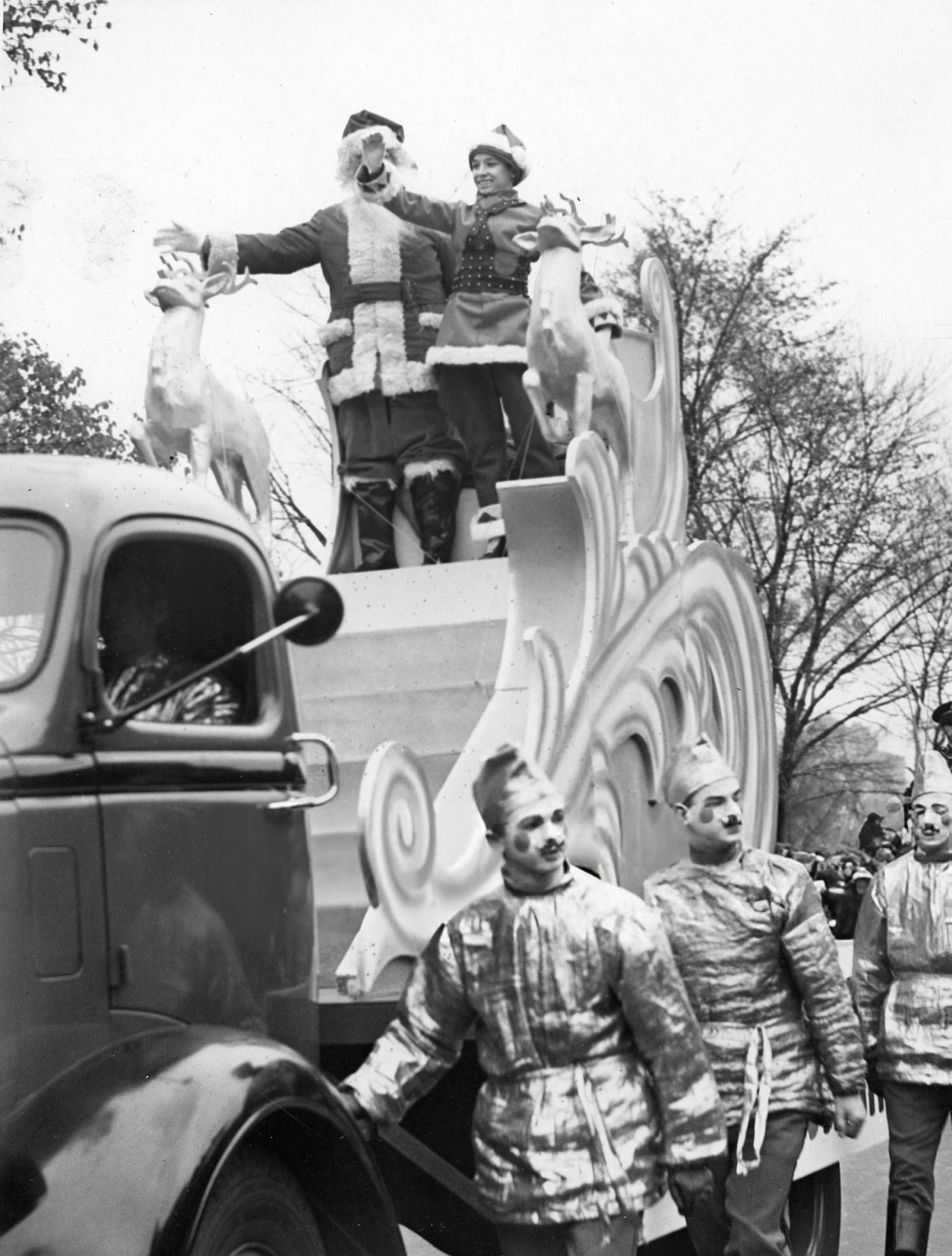 Santa Claus and Santason wave to the crowd from their float in Boston's annual Santason parade, 1938.