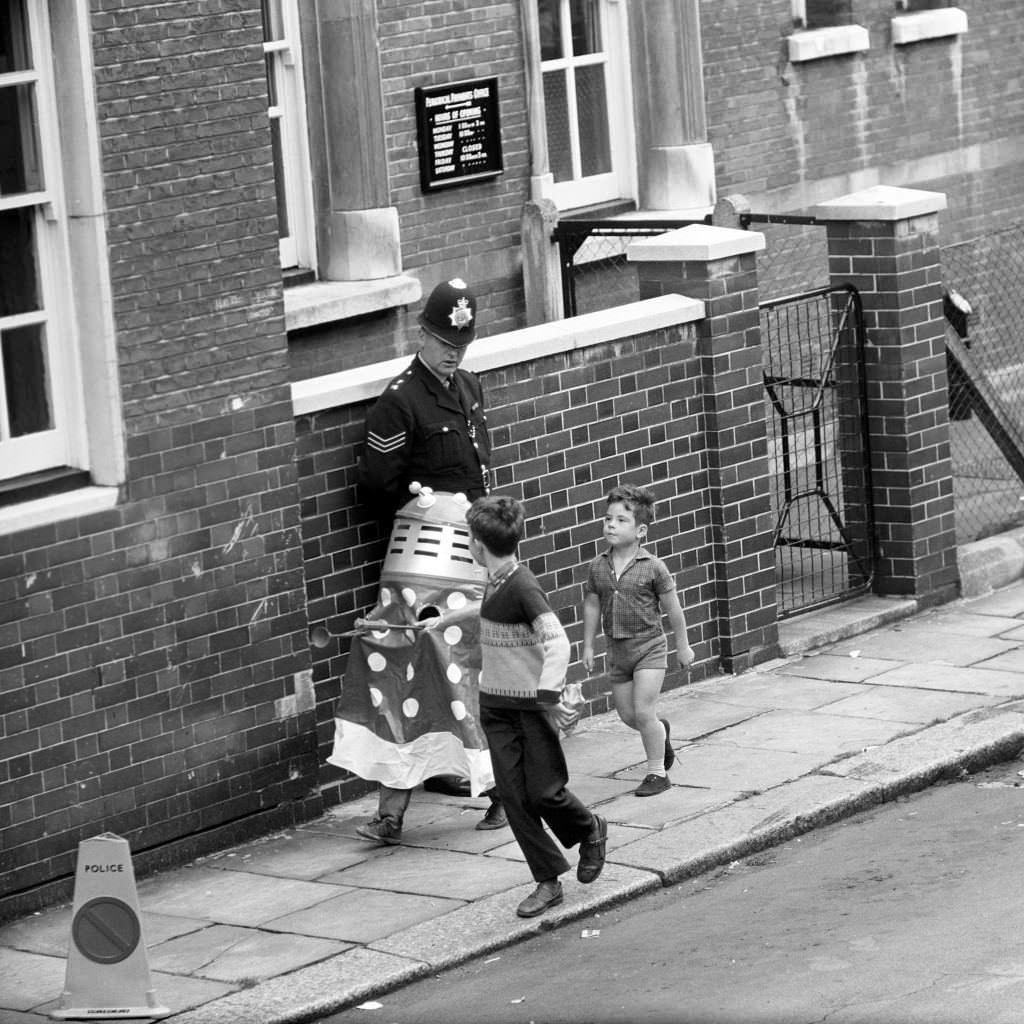 A boy hiding under a Dalek suit while John Edward Witney was ushered out of the West London Magistrate’s Court, 1966.