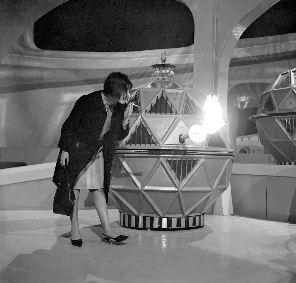 Verity Lambert lighting a cigarette from one of the mechanoid flame guns from the new Dalek series, 1965.