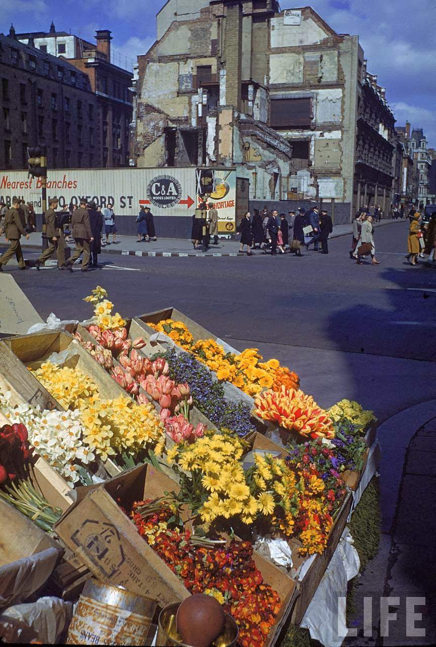 Small flower market (note American soldiers walking in background, L) during WWII.