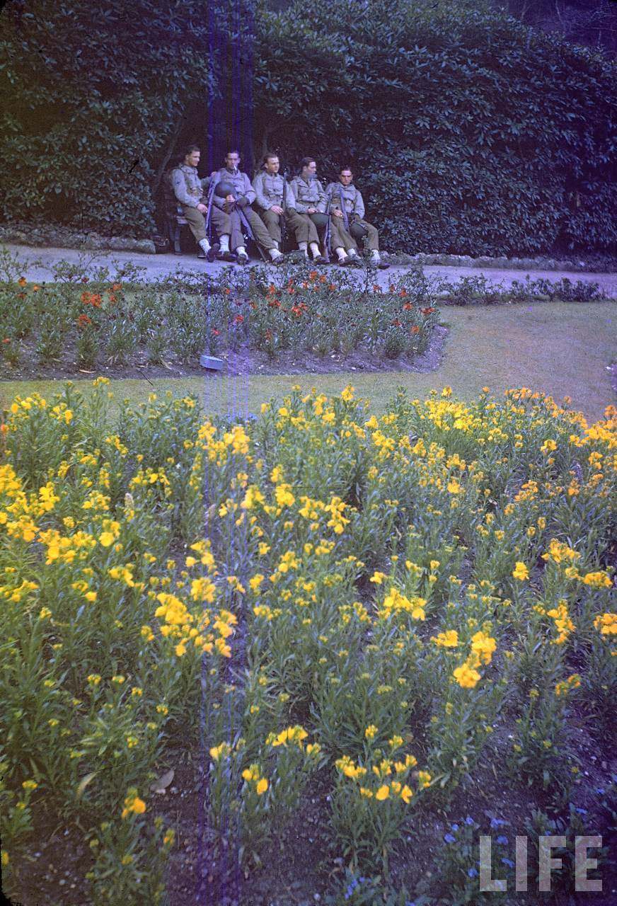 American infantrymen taking breather during a march in an unident. park shortly before D-Day.