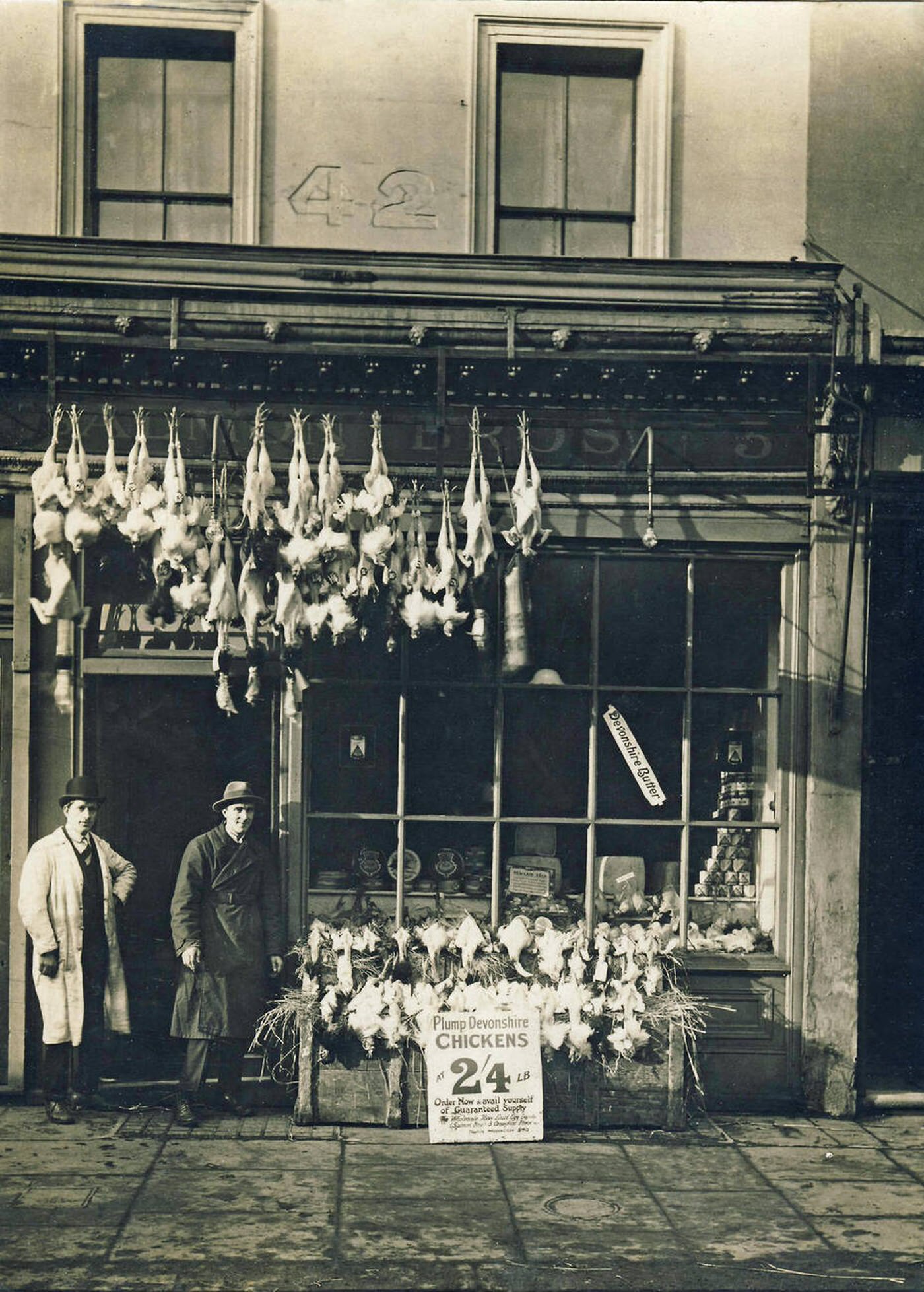 Men outside a poulterer's shop in London with a display of poultry, 1900s.