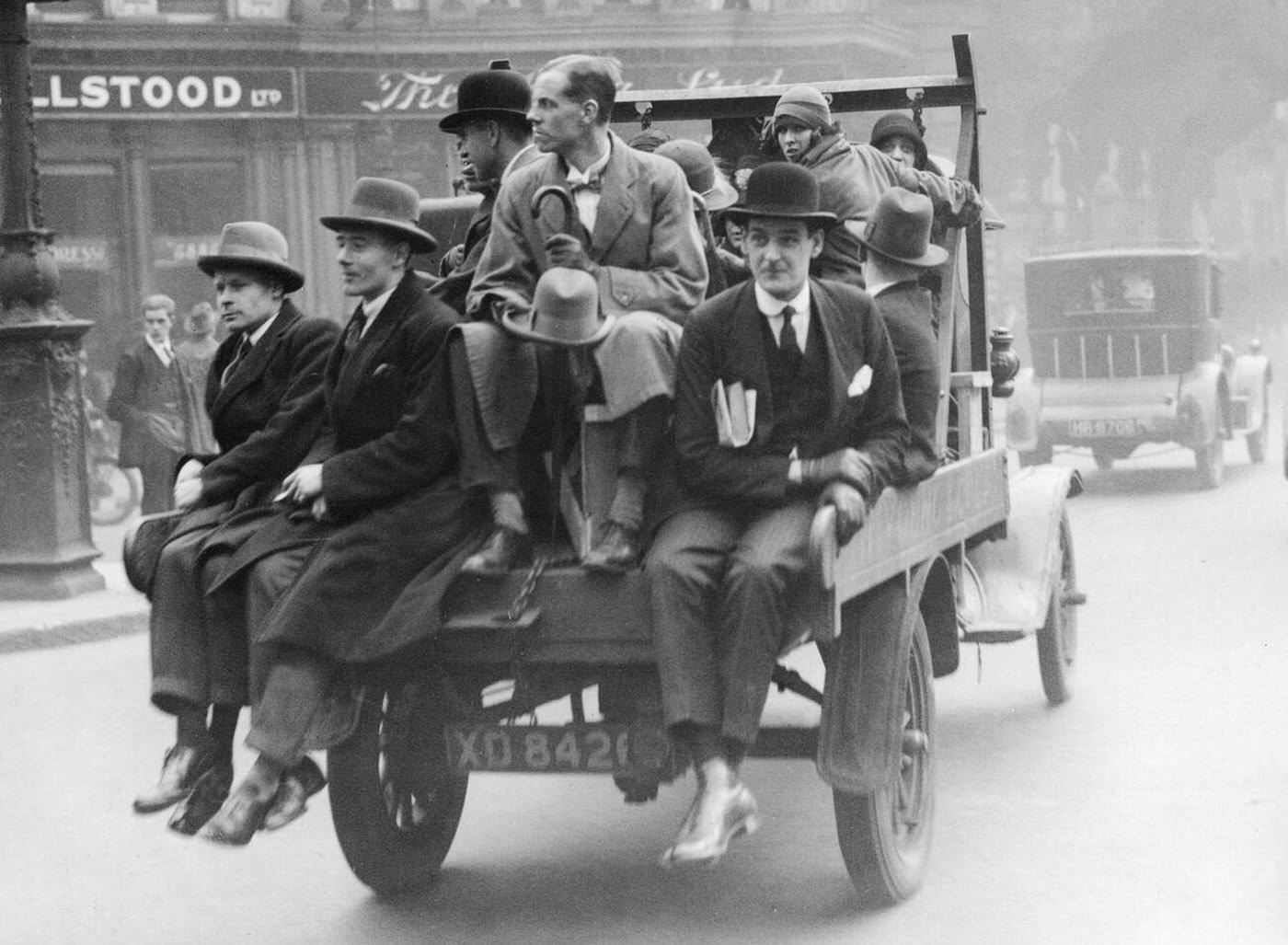 Businessmen in London commute into the city on the back of a truck during a local transport strike.