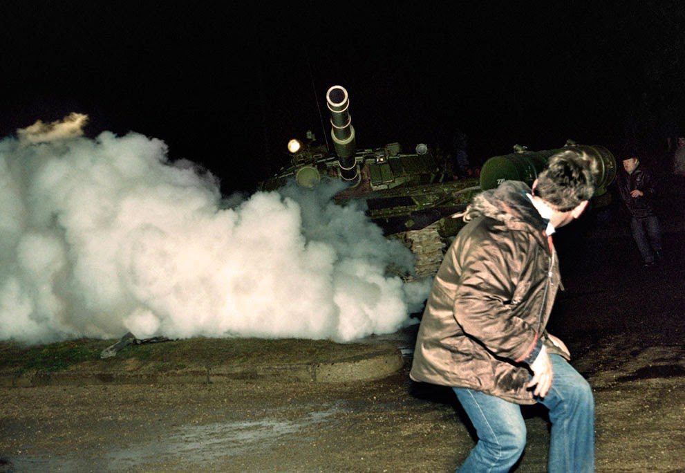 A Lithuanian demonstrator runs in front of a Soviet Red Army tank during an assault in Vilnius, 1991.