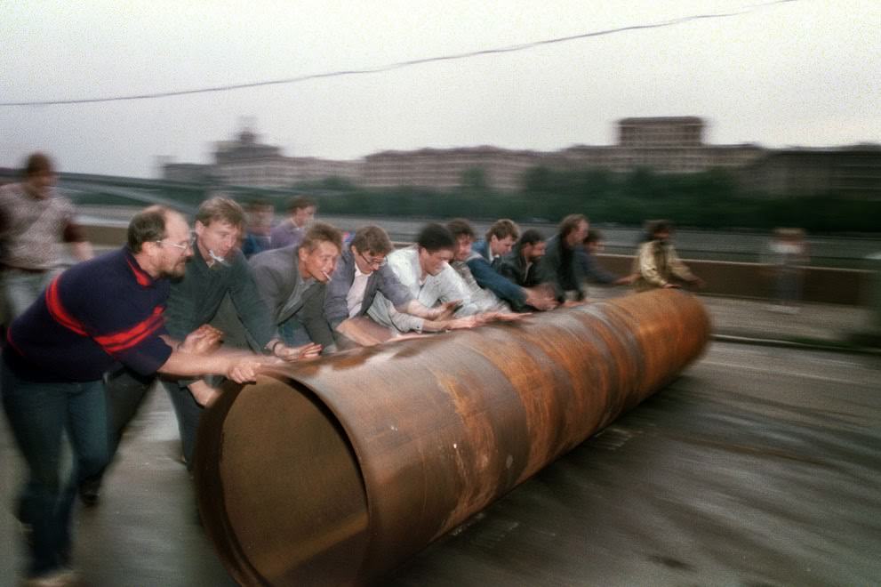 Supporters of Russian president Yeltsin roll a large metal pipe to use as a barricade in Moscow, 1991.