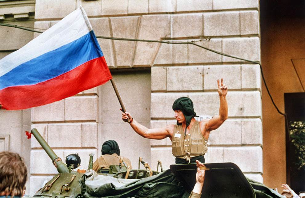 A soldier waves a Russian flag as armored units leave Moscow, 1991.