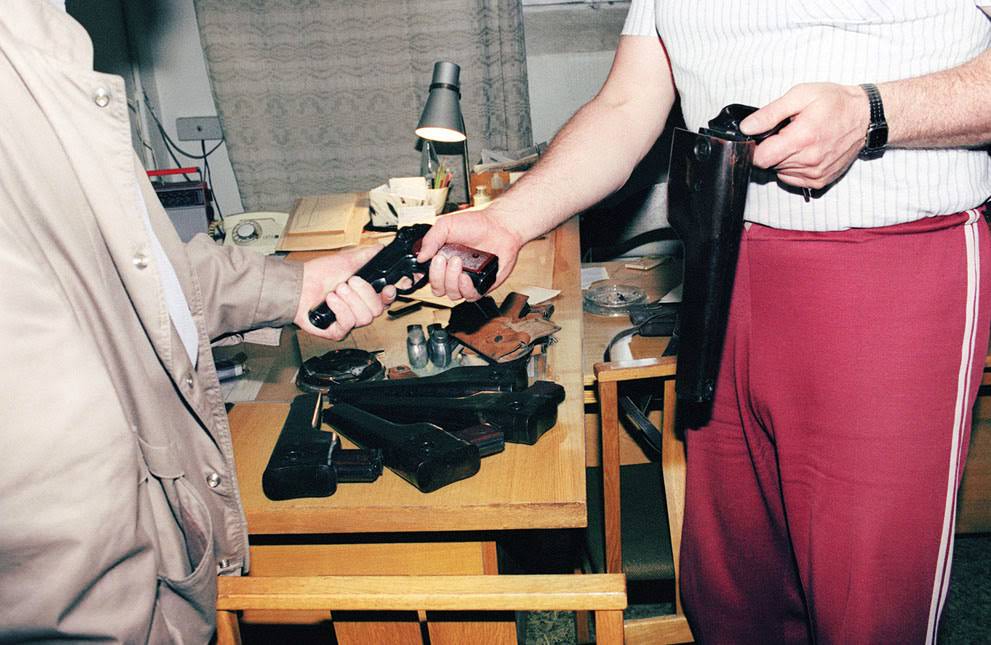 A member of the KGB hands over his weapon to a Lithuanian official in Vilnius, 1991.