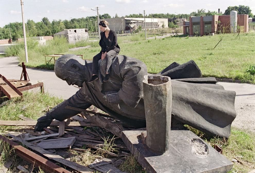 A girl sits on the toppled statue of Vladimir Lenin in Vilnius, 1991.
