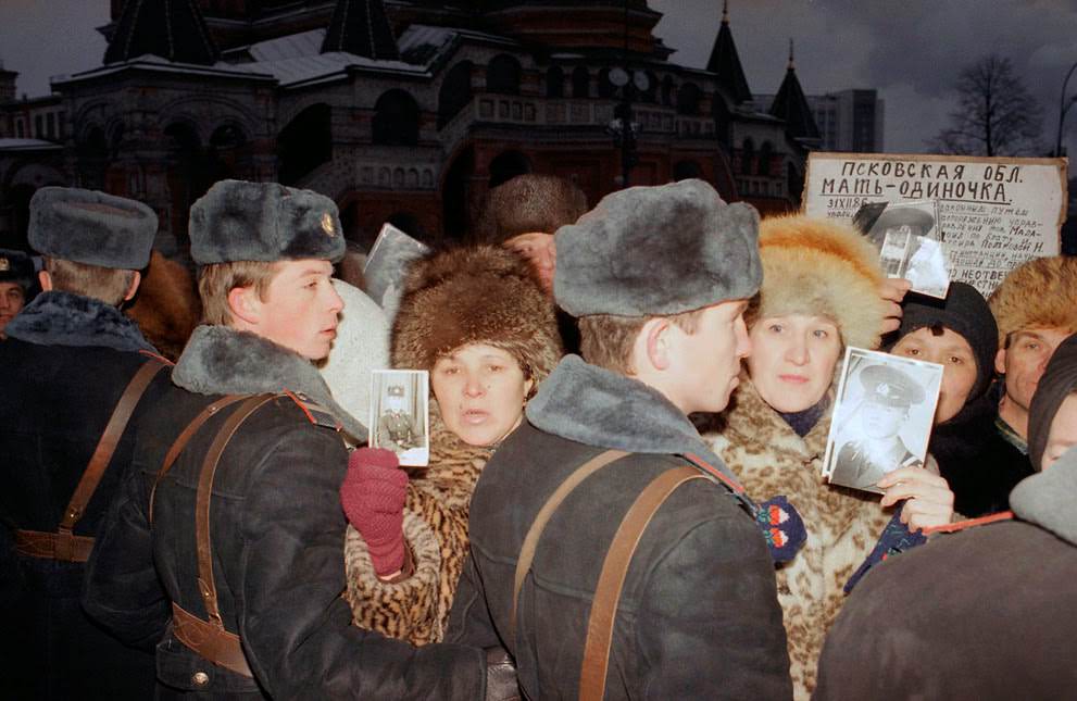 Soviet mothers hold photographs of their sons lost in the Red Army in Red Square, 1990.