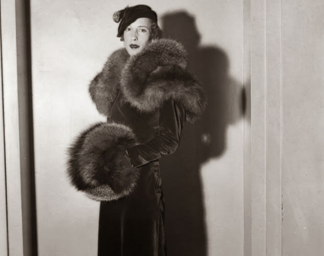Tres chic! A woman models an over the top red velvet ensemble during a fashion show in 1933.