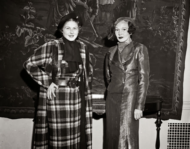 Two models cover up in fashionable women's suits at a 1933 show.
