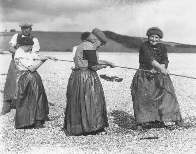 Old women in Devon haul in the day's catch of fish with a stout rope, 1927.