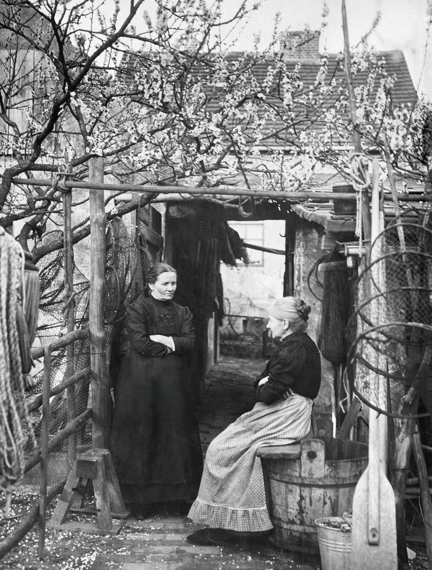 Two women in the backyard of a homestead, Bavaria, possibly fisherwomen, 1910.