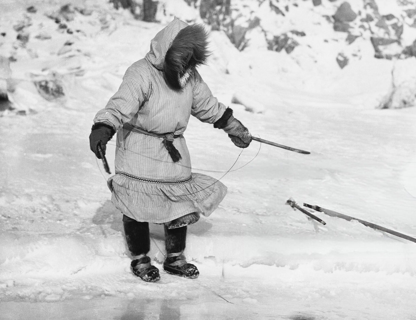 Inuit woman fishes with a simple hook.