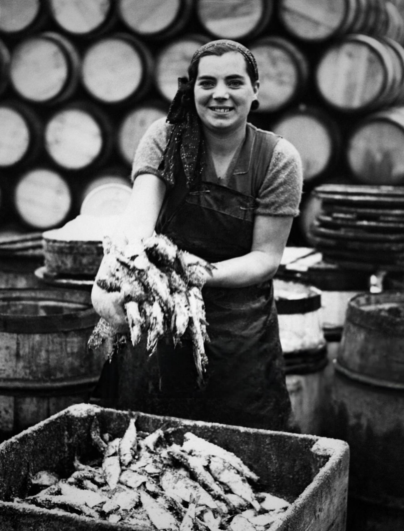 A Scottish fisherwoman showing the herrings, in Yarmouth, UK, 1937.