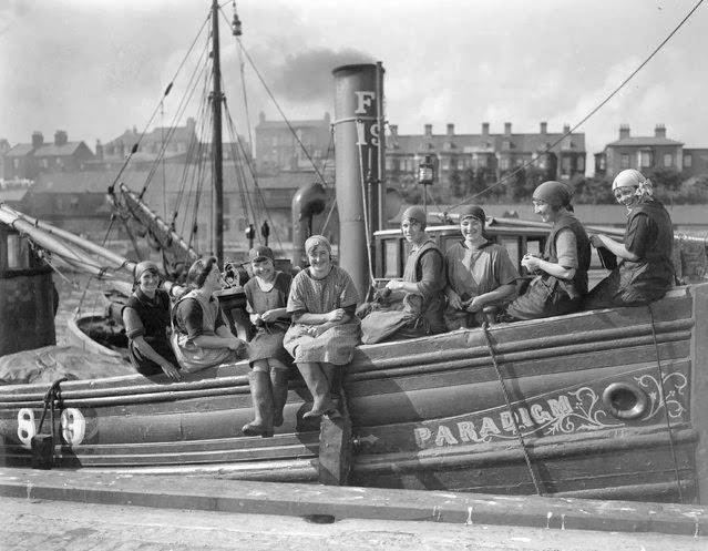 Scottish fisherwomen arrive at Great Yarmouth aboard the fishing vessel “Paradigm” for the autumn herring season, 1928.