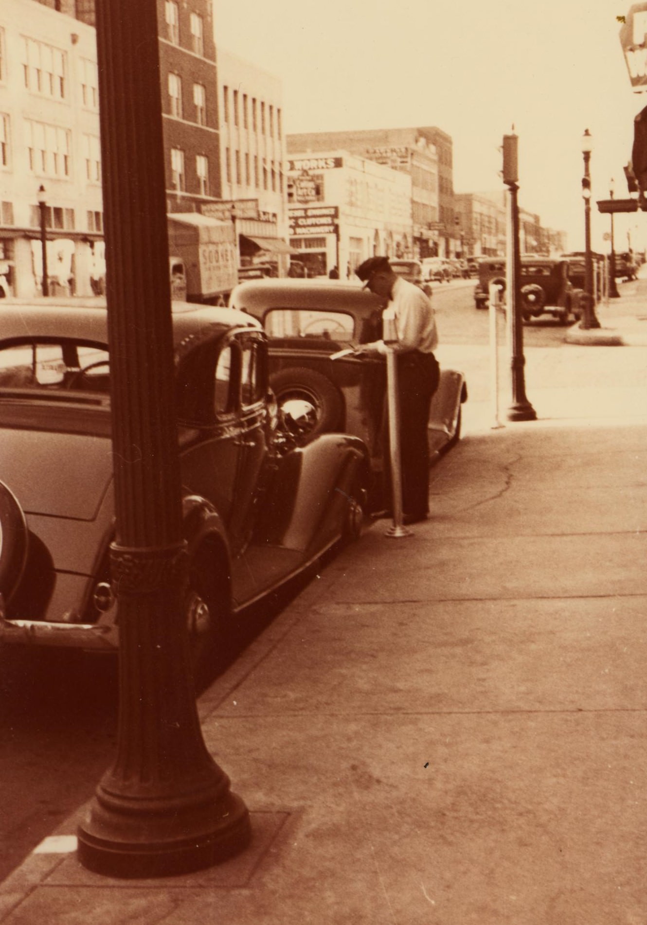A police officer writing a parking ticket, 1930s.