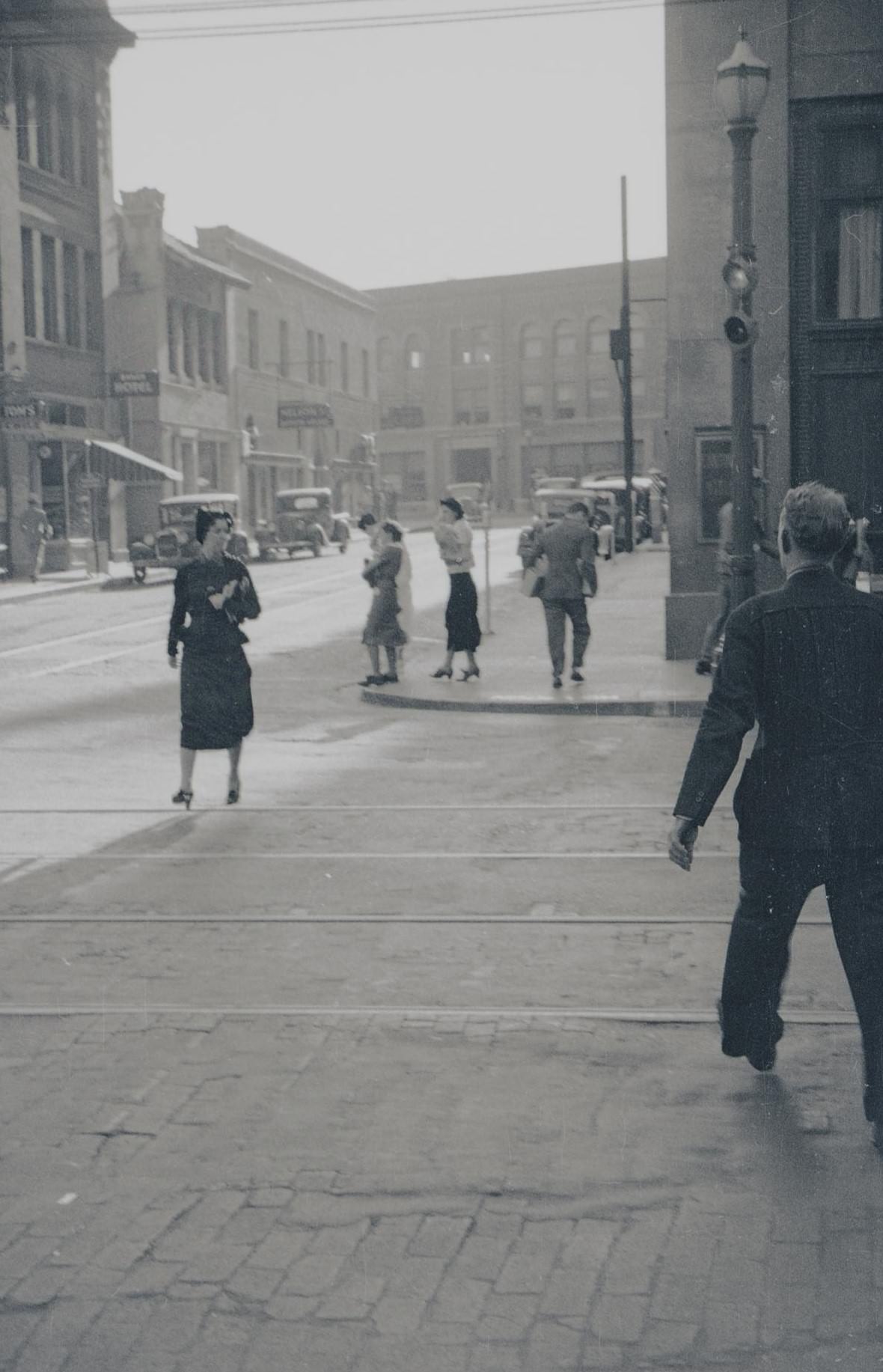 Pedestrians walking and crossing an intersection in Fort Worth, Texas, 1930s.