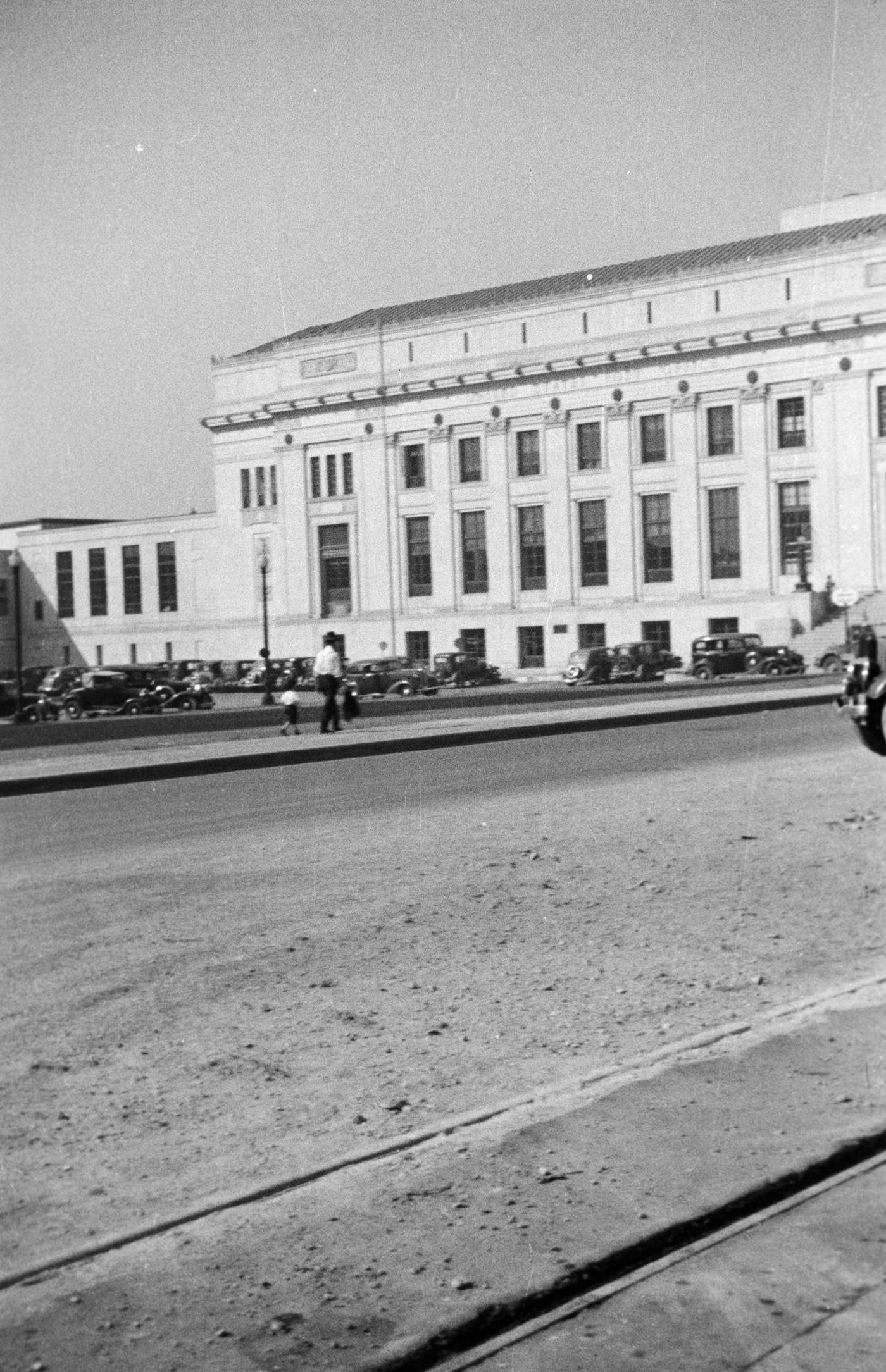 An empty street by a large stone building in Fort Worth, Texas, 1930s.
