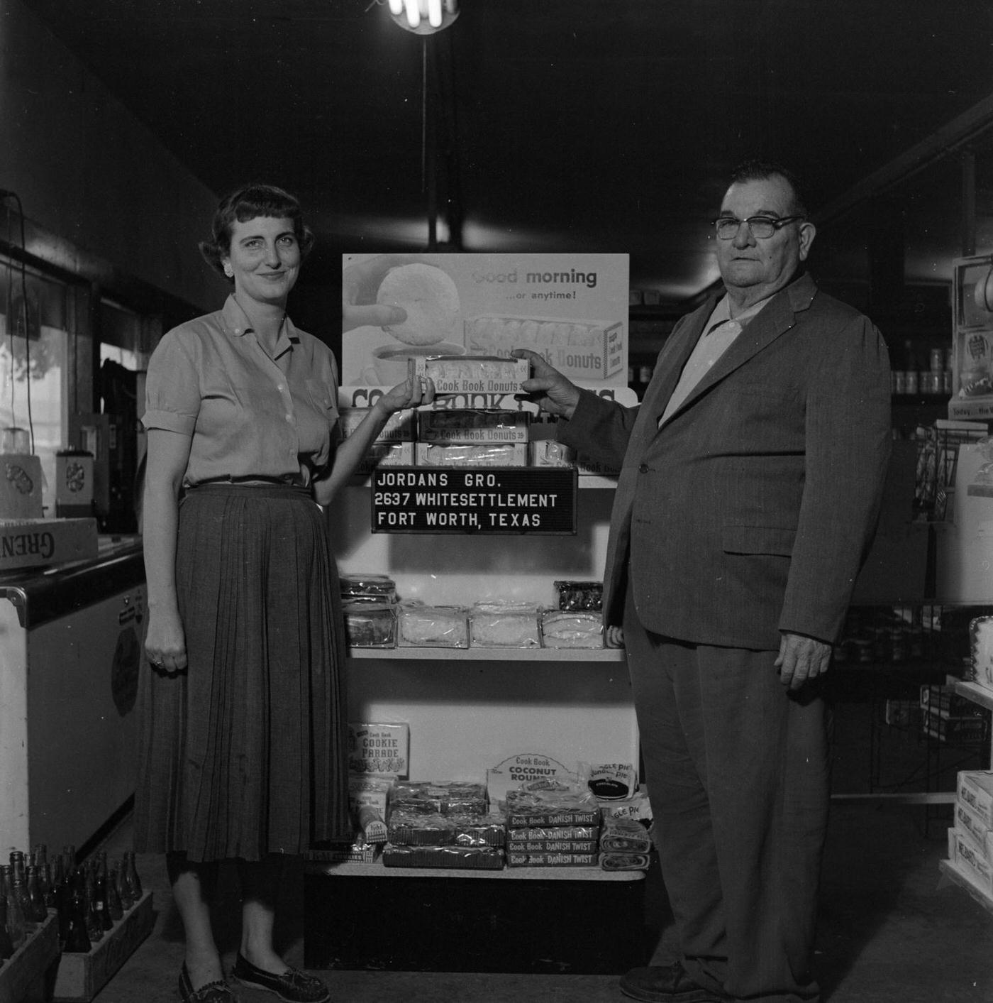 A man and woman with a Cook Book Donuts box at Jordan's Grocery, Fort Worth, 1957.