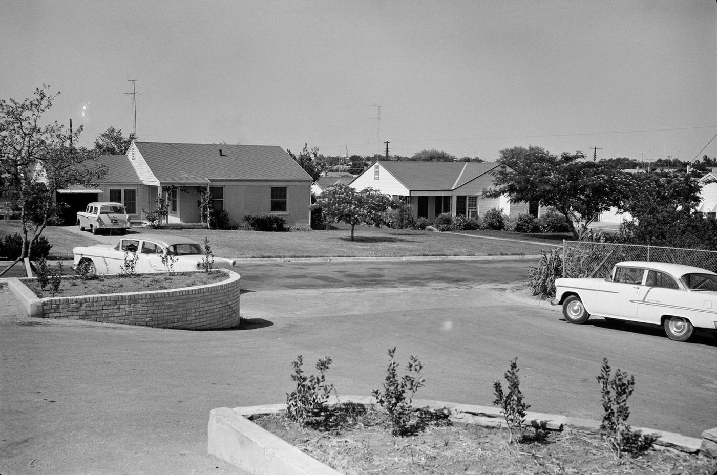 A Fort Worth neighborhood street scene with parked cars, 1950s.
