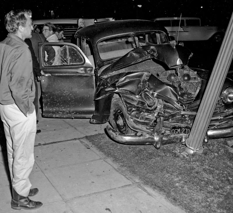 This 1948 Plymouth collided with a 1955 Buick Century at Fresno and R Streets before taking out this street light, Fresno, April 2, 1964