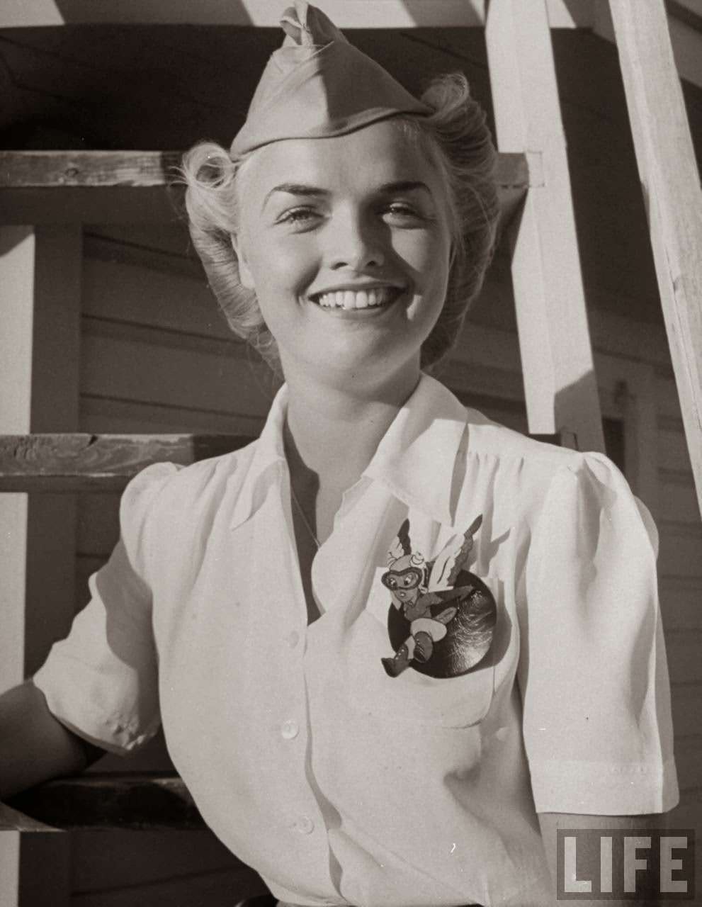 Anne Armstrong McClellan, pilot trainee in Women's Flying Training Detachment, sporting an official dress uniform of white blouse, tan slacks and overseas cap & a Fifinella mascot pin designed for the girl pilots by Walt Disney, at at Avenger Field.