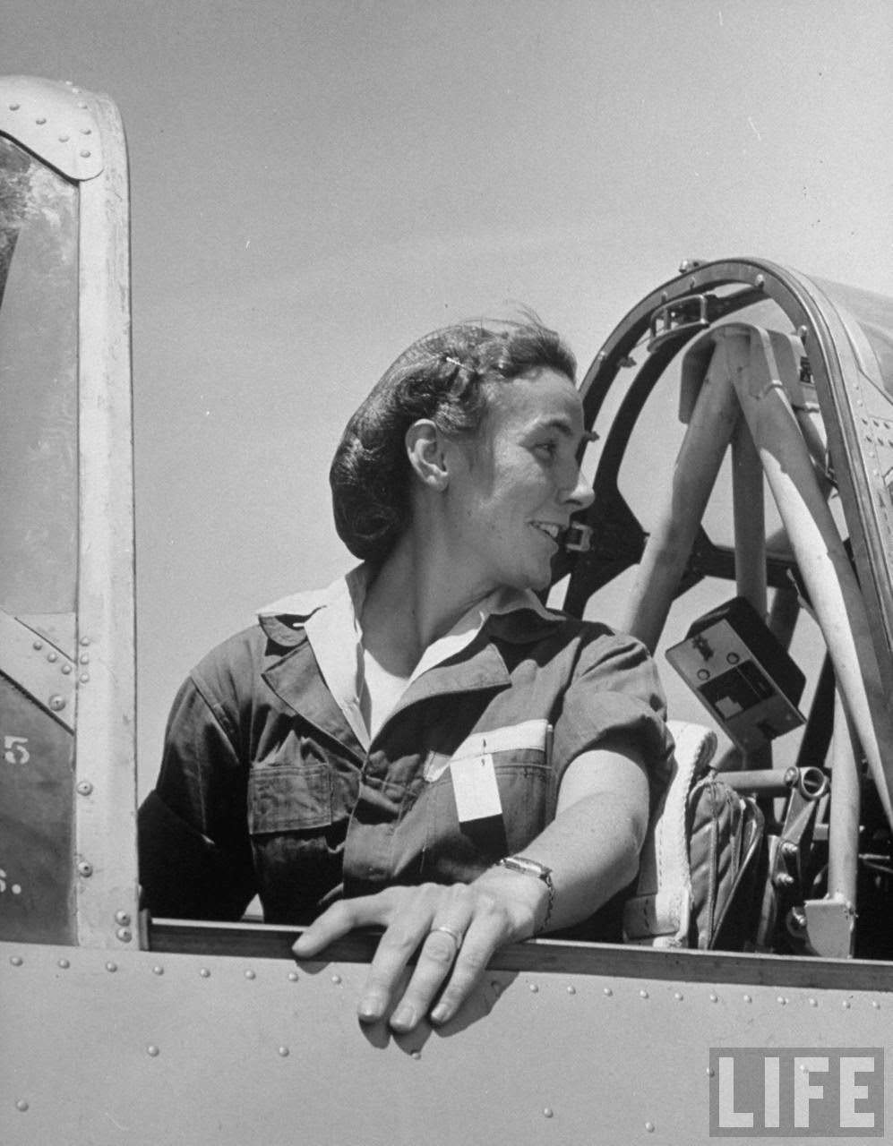 Forence Knight, pilot trainee in Women's Flying Training Detachment, to qualify for joining the all-civilian Women's Auxiliary Ferrying Squadron, using a hairnet to keep hair fr. flying, in cockpit of trainer before takeoff at Avenger Field.