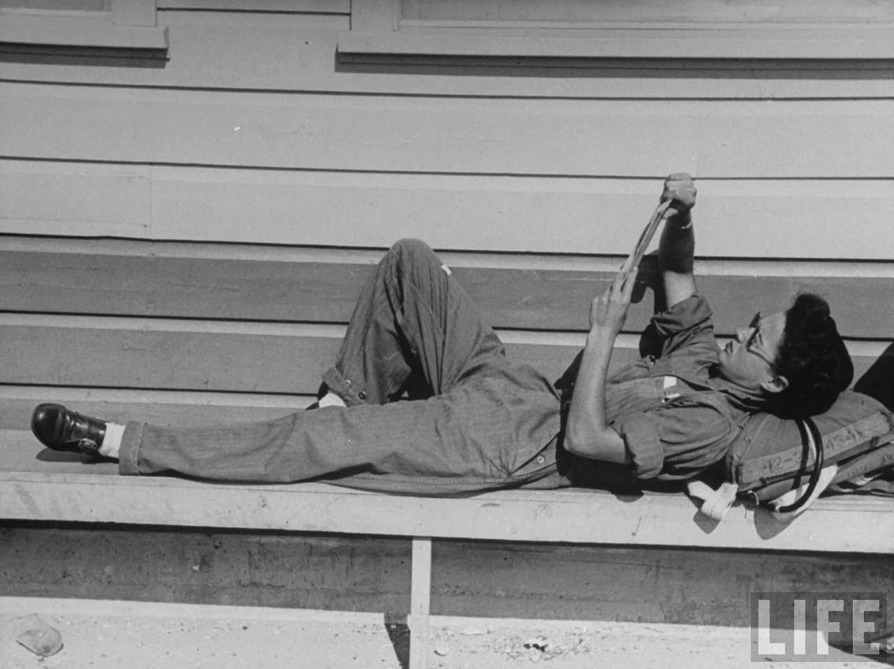 Jean Landis, a member of the Women's Flying Training Detachment, reading while using her parachute for a pillow as she relaxes between instrument training flights at Avenger Field.