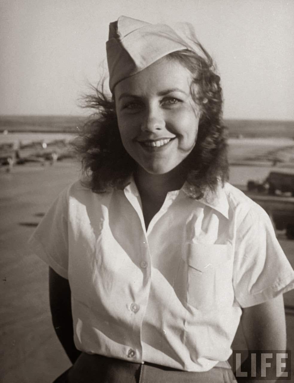 Shirley Slade, pilot trainee in Women's Flying Training Detachment, sporting an official dress uniform of white blouse, tan slacks and overseas cap, during training at Avenger Field.