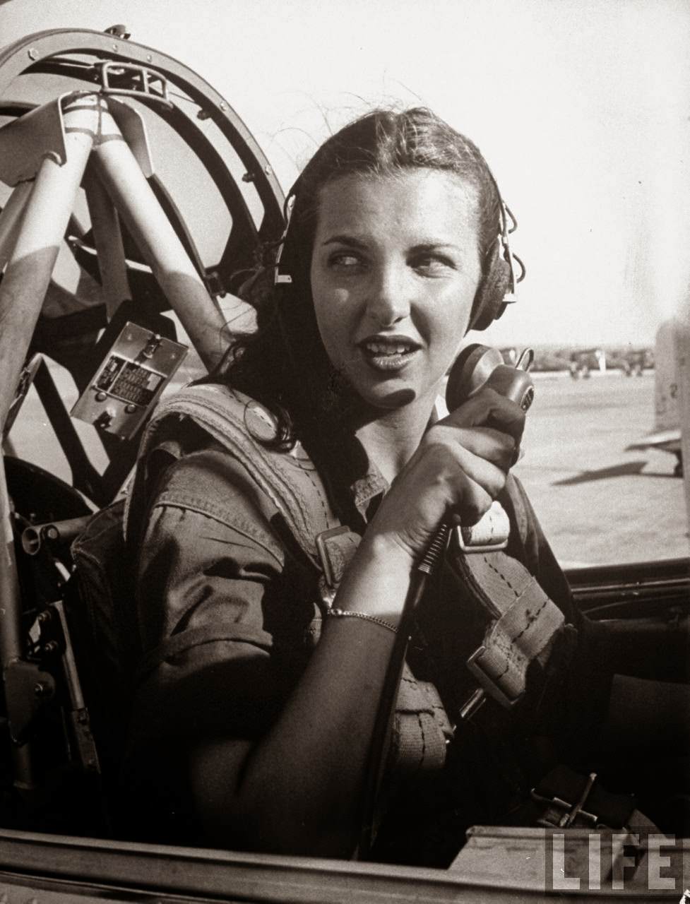 Nancy Nesbit, pilot trainee in Women's Flying Training Detachment, to enter the all-civilian Women's Auxiliary Ferrying Squadron, using earphones & mike as she checks w. control tower fr. the cockpit of her single engine Army trainer at Avenger Field.