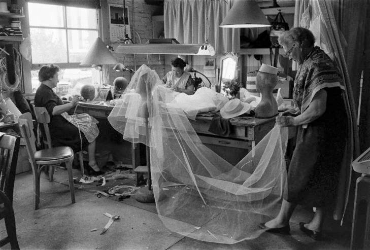 Seamstresses work on Grace Kelly's wedding dress and veil, conceived by MGM's wardrobe designer, Helen Rose, Hollywood, Calif., 1956