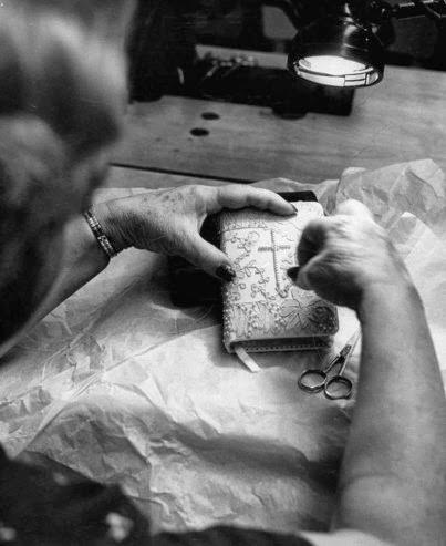A woman puts the finishing touches on the pearl-studded prayer book for Grace Kelly's wedding, Hollywood, Calif., 1956