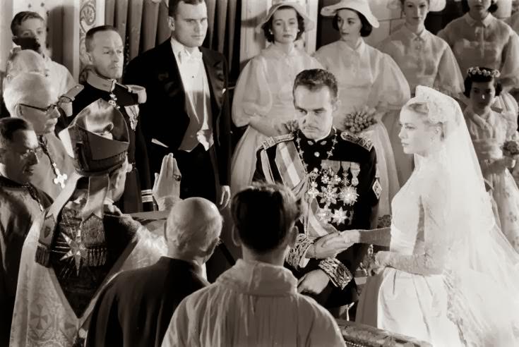 Grace Kelly and Prince Rainier join hands as the Bishop of Monaco, Mgr. Gilles Barthe, administers the nuptial benediction at Saint Nicholas Cathedral, April 1956